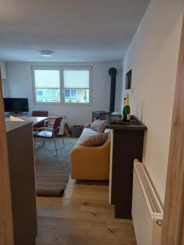 ein Wohnzimmer mit einem gelben Sofa und einem Tisch in der Unterkunft Ferienhaus Am-moore in Steindorf am Ossiacher See
