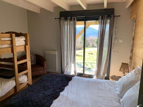 une chambre avec un lit et une grande fenêtre dans l'établissement Le Chalet de Juliette, à Gérardmer