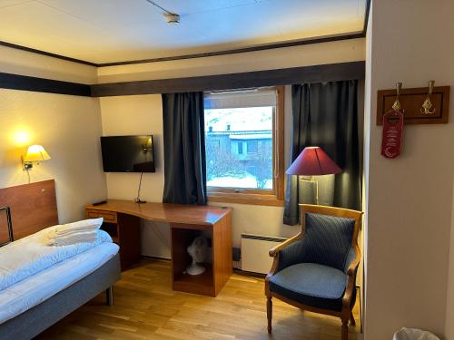 Habitación de hotel con escritorio, cama y silla en Camp Skytterhuset en Hammerfest