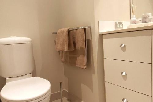y baño con aseo blanco y toallero. en Bannister Apartment in vibrant central Fremantle, en Fremantle