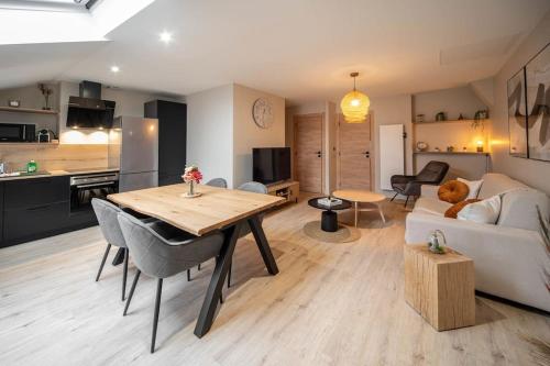 sala de estar y cocina con mesa y sofá en Appart de standing - Centre-ville, en Chalon-sur-Saône
