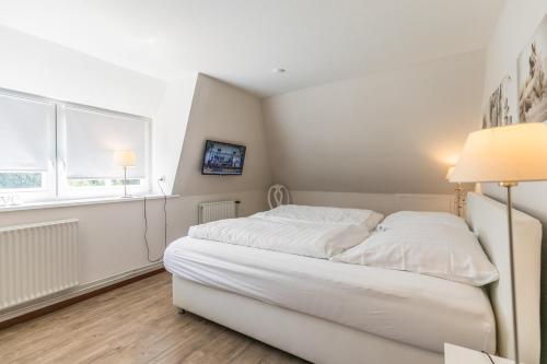 a bedroom with a white bed and two windows at "Beach House" Beach House, Whg 1 in Westerdeichstrich