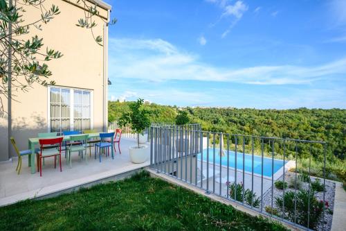 a balcony with a table and chairs and a pool at Villa Volare Cantare with 2 br, a heated pool and panoramic view near Buje, Istra in Momjan