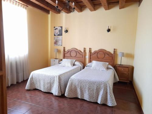 um quarto com 2 camas com lençóis brancos e uma janela em El Molino em Nieva