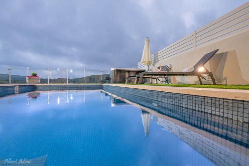a swimming pool with blue water in front of a building at סוויטות Sol - סוויטות מהממות בגליל עם בריכה וג'קוזי במתחם in Gornot HaGalil