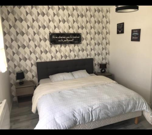 a bedroom with a bed and a sign on the wall at Les Gîtes de la Colo in Ravenoville