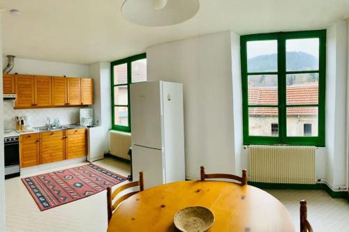 a kitchen with a wooden table and a refrigerator at Grand Messier 8 personnes in Senones