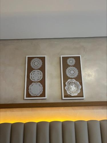 two framed pictures on a wall above a counter at Pousada Kiriri in Itarema