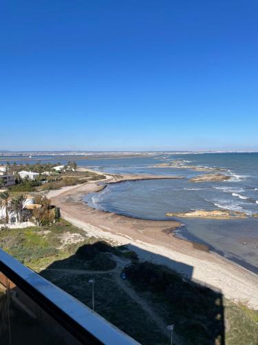 a view of the beach from the balcony of a condo at Seafront La Manga Apartment in La Manga del Mar Menor