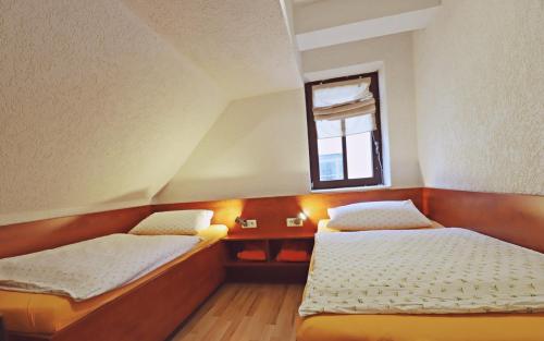 two beds in a small room with a window at Pension Hinz & Kunz in Weimar