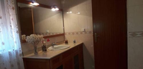 a bathroom with a sink and a large mirror at Casa da Cândida in Nazaré