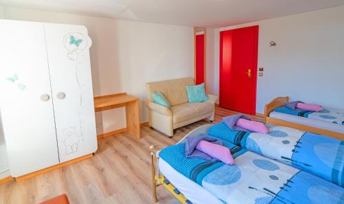 a bedroom with two beds and a chair in it at Residence Jungfrau in Interlaken