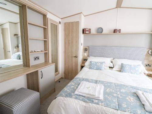 um quarto com uma cama grande e um espelho em Balmoral em Pendine