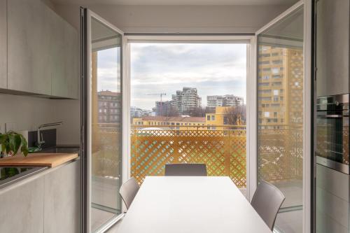 cocina con mesa blanca y ventana grande en BnButler - Flavio Gioia, 5 - Appartamento con Vista, Citylife en Milán