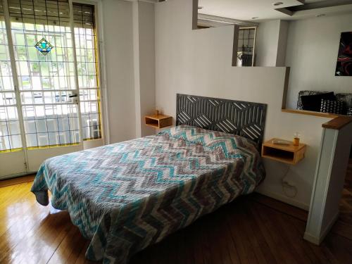 ein Schlafzimmer mit einem Bett in einem Zimmer mit Fenstern in der Unterkunft Departamento Unico en Recoleta !! Ubicacion Excelente. in Buenos Aires