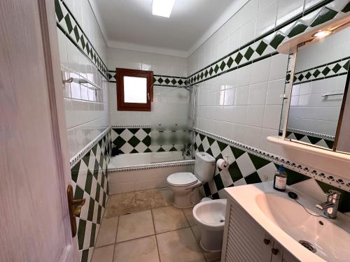 een badkamer met een toilet, een wastafel en een bad bij Villa Sanchez in Strandnähe mit Pool, Jacuzzi, Klima, WiFi, Gas BBQ in Santanyi