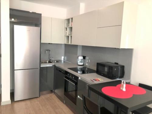 a kitchen with a black counter and a white refrigerator at Secured Lux 1 + 1 apartment - Gym, Sauna & Parking ( EMP 142 ) in Esenyurt