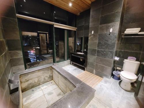 a bathroom with a toilet and a shower with a sink at Yuanben Mountain Hot Spring Homestay in Jiaoxi