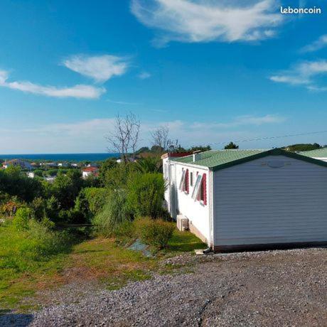 une petite maison assise sur le côté d'une route dans l'établissement Mobil-home avec vue mer, à Saint-Jean-de-Luz