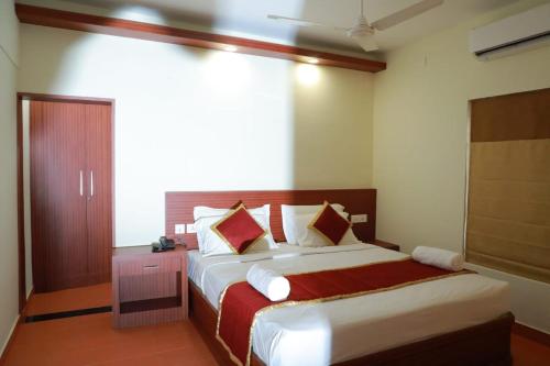 a bedroom with a large bed with a red blanket at Pearlspot Hotel in Kumarakom