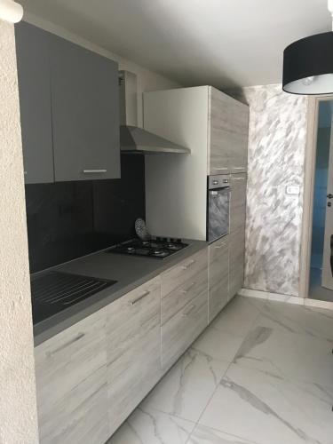 a kitchen with white cabinets and a stove top oven at Apartments Barbara in Poreč
