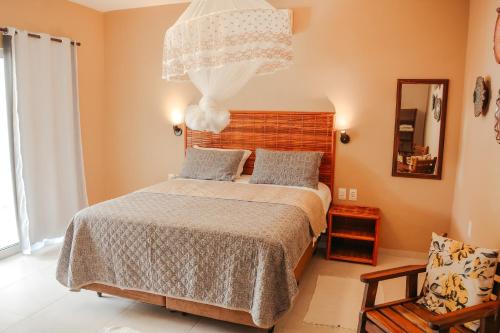 a bedroom with a bed and a large window at Ajubá Pousada in Morro de São Paulo