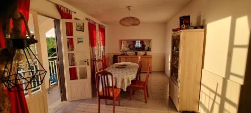 a kitchen with a table and a kitchen with a refrigerator at Case Tortue - chambres chez l'habitant - 3 étoiles in Les Avirons