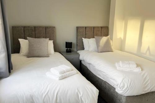 dos camas sentadas una al lado de la otra en una habitación en Kingfisher House by Blue Skies Stays en Stockton-on-Tees