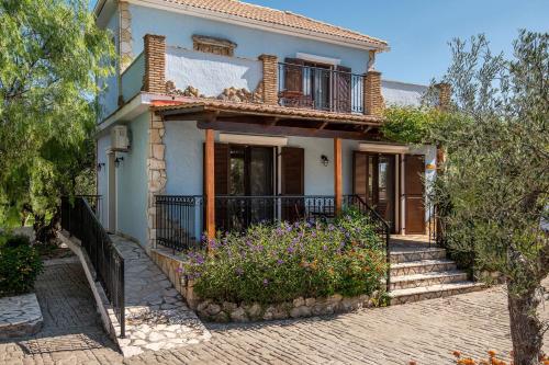 a house with a balcony and flowers in front of it at Olive Tree Villas in Kipseli