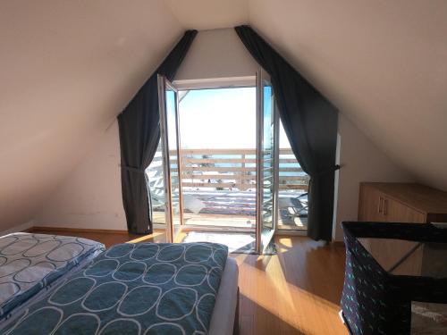1 dormitorio con cama y ventana grande en Hiša v mesečini - Moonlight house, en Cerklje na Gorenjskem