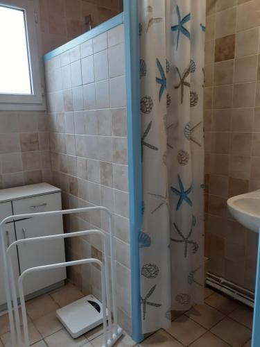 uma casa de banho com uma cortina de chuveiro e um lavatório em Maison vacances d'Oléron em La Brée-les-Bains