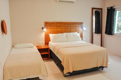 een slaapkamer met 2 bedden in een kamer bij Ajubá Pousada in Morro de São Paulo