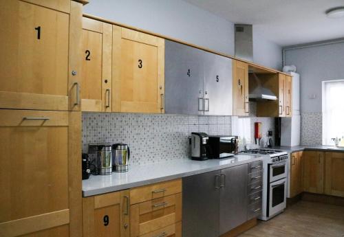 a kitchen with wooden cabinets and stainless steel appliances at Desire Residence in London