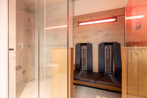 a glass shower stall with a bench in a bathroom at Chalet 149 Westendorf by ALPS RESORTS in Westendorf
