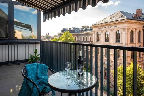 a balcony with a table and two wine glasses at InPoint Central Apartments Old Town&Kazimierz - Free Parking in Krakow