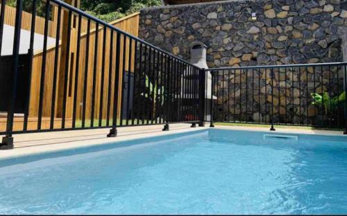 una piscina con una valla de hierro y un organismo oficial en Villa Cap Méchant piscine chauffée avril à octobre, en Saint-Joseph