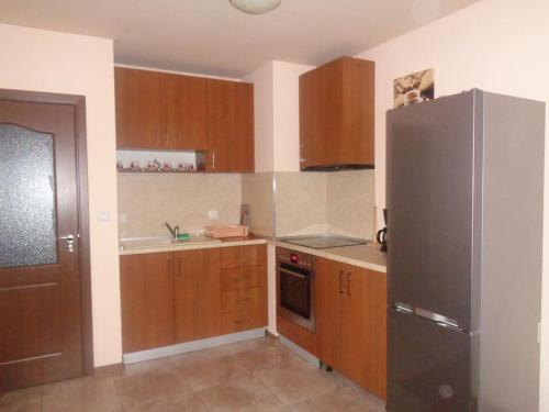 una cucina con armadi in legno e frigorifero in acciaio inossidabile di Home Relax Varna a Varna