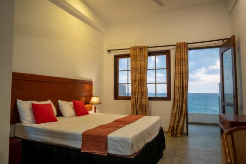 a bedroom with a bed with a view of the ocean at Sea Breeze Ambalangoda in Ambalangoda