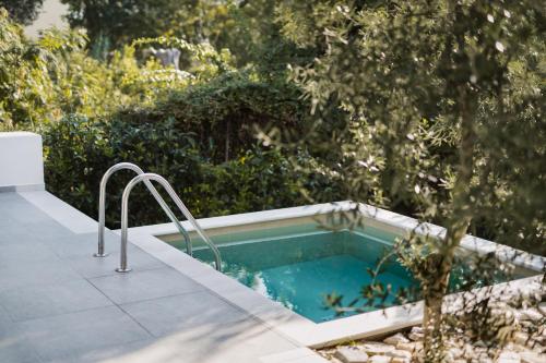 einen Pool in einem Garten neben einem Baum in der Unterkunft Octo Villas Complex in Nea Iraklitsa