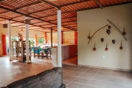 a living room with a couch and a dining room at Ajubá Pousada in Morro de São Paulo