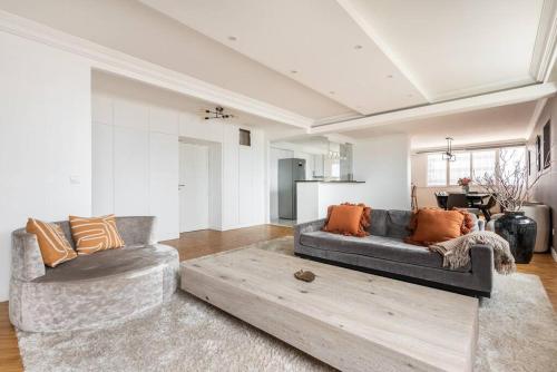 un salon avec un canapé et deux chaises dans l'établissement Appartement luxueux vue Tour Eiffel - Defense, à Puteaux