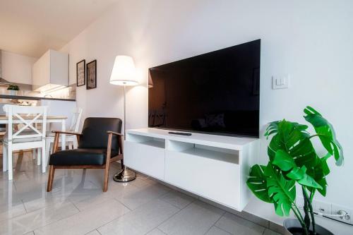 ein Wohnzimmer mit einem großen Flachbild-TV an der Wand in der Unterkunft Isabella Apartment by Quokka 360 - with a lake view on the Melide bridge in Melide