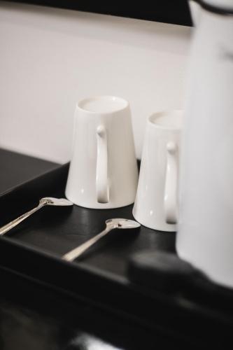 three white cups sitting on a black table at Gemilang Hotel in Kota Kinabalu