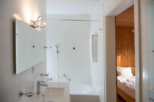 a bathroom with a sink and a mirror and a bed at Residence for 12 persons Chalet Crestas-Lenzerheide in Lenzerheide