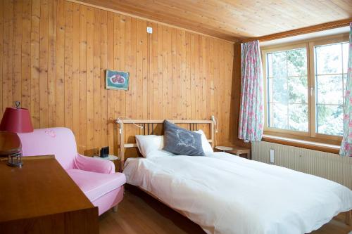 a bedroom with two beds and a desk and a window at Residence for 12 persons Chalet Crestas-Lenzerheide in Lenzerheide