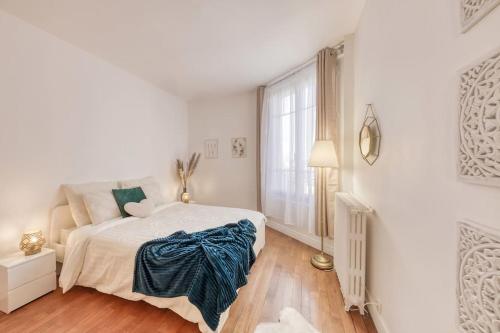 a white bedroom with a bed and a window at Oh Parisien - 10 min Paris Montparnasse in Vanves