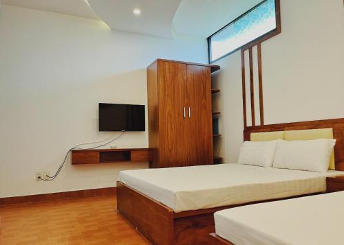 1 dormitorio con 1 cama y TV en la pared en Đức Tuân 2 Motel en Hai Phong