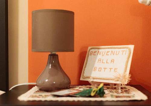 a lamp sitting on a table next to a sign at B&B La Botte - Taurasi in Taurasi