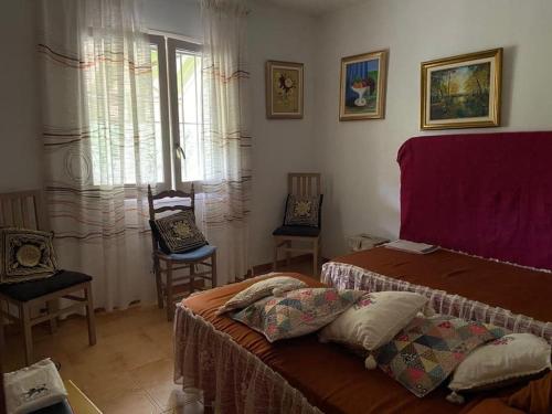 a bedroom with a bed and two chairs and a window at Villa Òdena in Odena