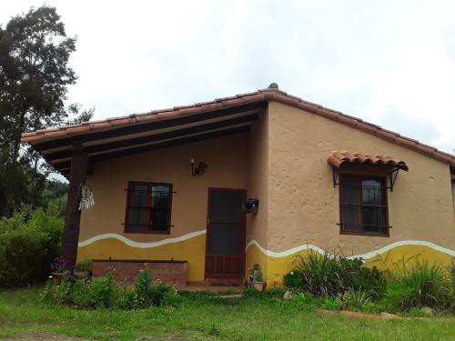 a small yellow house with a roof at Casa Amaranta in Samaipata